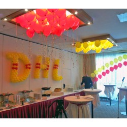 Корпоративное оформление красно-жёлтыми воздушными шарами под потолок и плетенные буквы