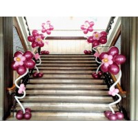 Бордово-розовые цветочки из воздушных шаров для оформления лестницы