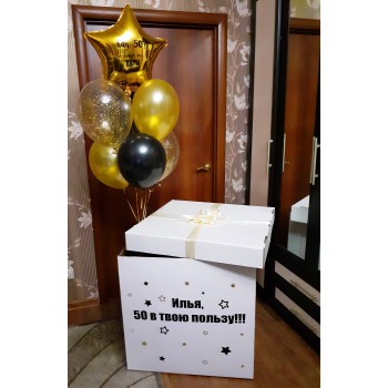 Большая коробка-сюрприз с надписью "Илья, 50 в твою пользу!!!" и с фонтаном из гелиевых шаров чёрно-золотой 