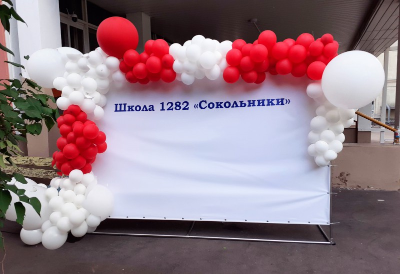 Оформление баннера красно-белой разнокалиберной гирляндой 