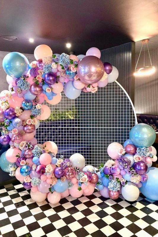 Круглая фотозона из разнокалиберной гирлянды с цветами в пастельных тонах на сетчатом каркасе